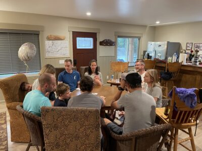Family playing cards around table
